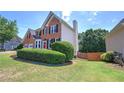 Brick home with green yard, featuring a spacious lawn and privacy landscaping at 1124 Monarda Nw Way, Acworth, GA 30102