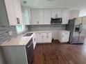 Bright kitchen features white cabinets, stainless steel appliances, quartz countertops, and a mosaic backsplash at 2127 Whites Mill Rd, Decatur, GA 30032