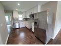 This bright kitchen features white cabinets, stainless steel appliances, quartz countertops, and wood floors at 2127 Whites Mill Rd, Decatur, GA 30032