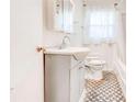 Well-lit bathroom features a charming vanity, patterned floor tiles, and a built-in medicine cabinet at 5136 Jones Rd, Forest Park, GA 30297