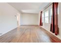 Spacious living room with shiny hardwood floors, a large window and view to another room at 5136 Jones Rd, Forest Park, GA 30297