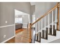 Inviting foyer with wood floors and white trim, showcasing the staircase and a glimpse into the living room beyond at 955 Chandler Haulk Rd, Loganville, GA 30052