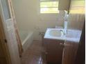 Modest bathroom featuring a tub/shower combo, tiled walls, and basic vanity with storage at 1275 Bell Ave, Atlanta, GA 30344