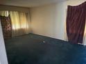 Empty living room with large windows, curtains, and dark blue carpeting ready to be refreshed at 1275 Bell Ave, Atlanta, GA 30344