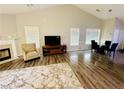 Living room featuring hardwood floors, a fireplace and an adjacent dining area at 2550 Kentshire Way, Lawrenceville, GA 30044