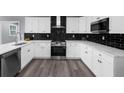 Beautiful kitchen features white cabinets, stainless steel appliances, and modern backsplash at 4605 Tims Pl, Snellville, GA 30039