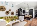 Bright living room featuring high ceilings, wood floors, stylish decor, and open kitchen concept at 135 Mado Ln, Chattahoochee Hills, GA 30268