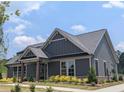 Charming single story home with gray siding, stone accents, well-manicured lawn and inviting curb appeal at 2255 Windsor Bluffs Dr, Cumming, GA 30041