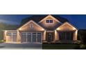Stunning exterior home view featuring a well-lit facade, brick accents, and a two-car garage at night at 2255 Windsor Bluffs Dr, Cumming, GA 30041