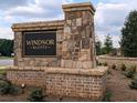 Stone monument sign for Windsor Bluffs community with manicured landscaping and welcoming entrance at 2255 Windsor Bluffs Dr, Cumming, GA 30041