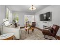 Bright living room with hardwood floors, modern lighting, comfortable seating, and a view into the dining area at 1734 8Th St, Brookhaven, GA 30341