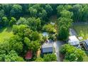 Aerial view of a wooded property featuring a home, outbuildings, and an above-ground pool at 2024 Lower Burris Road Rd, Canton, GA 30114