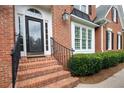 Brick steps lead to the detailed front door, framed by lush landscaping at 3361 Woodington Se Ct, Marietta, GA 30067