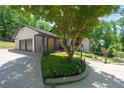 Charming home exterior with three car garage and beautiful landscaping, including flowering plants and manicured greenery at 9701 Buice Rd, Alpharetta, GA 30022