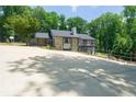 Back exterior view of house with lovely balconies and a large driveway, surrounded by lush green trees at 9701 Buice Rd, Alpharetta, GA 30022