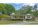Inviting single-story home featuring a cozy front porch and mature landscaping at 502 Allen Dr, Lawrenceville, GA 30043