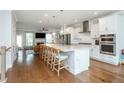 Modern, open kitchen with large island, stainless steel appliances, white cabinetry, and hardwood floors at 996 Layton Dr, Buford, GA 30518