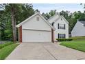 Two story traditional home with brick accents, attached garage and driveway with an expansive lawn at 1047 Woodsong Pass Ct, Lawrenceville, GA 30043