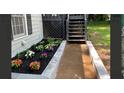 Home's landscaped walkway leading to the front door features lush flower beds and manicured plants at 840 Wells Se Cir, Smyrna, GA 30080