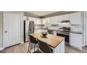A view of a bright kitchen with stainless steel appliances, granite countertops, white cabinets, and a center island at 840 Wells Se Cir, Smyrna, GA 30080