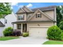Inviting two-story home with a covered front porch, two-car garage, and well-maintained lawn and shrubbery at 1537 Maplecliff Way, Sugar Hill, GA 30518