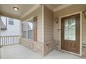 Charming covered front porch with brick accents and classic detailing, leading to the front door at 1537 Maplecliff Way, Sugar Hill, GA 30518