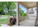 Inviting front porch with classic white columns and railings, offering a relaxing outdoor space at 1537 Maplecliff Way, Sugar Hill, GA 30518