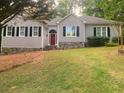 Charming single-story home features a manicured lawn, stone accents, and a welcoming red front door at 23 Timberlake Pointe Ne, Cartersville, GA 30121