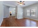 Open living room featuring hardwood floors, brick fireplace, large window, and a ceiling fan at 3361 Myrtle St, Atlanta, GA 30354