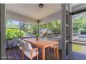 Virtually staged sunroom enclosed with many windows overlooking the outside, including dining furniture at 3361 Myrtle St, Atlanta, GA 30354