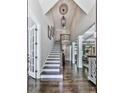 Elegant foyer features soaring ceilings, staircase, hardwood floors, and decorative lighting fixtures at 5039 Towne Lake Hills North, Woodstock, GA 30189