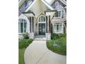 Elegant stone entryway featuring a beautiful arched door, columns, and decorative windows at 5039 Towne Lake Hills North, Woodstock, GA 30189