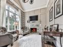 Cozy living room with a fireplace, comfortable seating, and a large window at 5039 Towne Lake Hills North, Woodstock, GA 30189