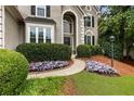 Close up of inviting front entrance featuring mature landscaping and a curved walkway leading to the front door at 5860 Fairway View Dr, Suwanee, GA 30024