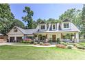 Inviting two-story home with a welcoming porch, dormer windows, and lush landscaping at 125 Foxridge Rd, Atlanta, GA 30327