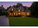 Twilight view of an attractive two-story brick home with a perfectly manicured lawn at 8970 Moor Park Run, Duluth, GA 30097