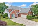 Attractive brick home with manicured lawn and extended driveway; complemented by mature trees and shrubbery at 5365 Glenhaven Dr, Cumming, GA 30041