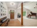 Welcoming foyer with bench seating, wood floors and a view into a formal sitting room with grand piano at 1031 Bailey Rd, Woodstock, GA 30188