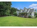A meticulously manicured front yard showcases a charming two-story home with a cozy front porch at 225 W Union Grove Cir, Auburn, GA 30011