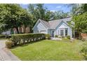 Well-maintained home with a lush green lawn, mature landscaping, and a two car garage at 4038 Sharon Woods Dr, Powder Springs, GA 30127