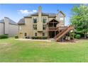 Expansive backyard featuring a wooden deck with stairs leading to a spacious grassy area at 4955 Winding Rose Dr, Suwanee, GA 30024