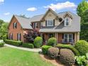 Beautiful brick home with manicured shrubbery and a covered front porch creating a welcoming entrance at 4955 Winding Rose Dr, Suwanee, GA 30024