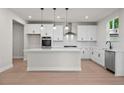 A stylish kitchen with white cabinets, an island, and stainless steel appliances at 910 Melody Ridge Ln, Buford, GA 30518