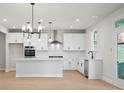 A stylish kitchen with white cabinets, an island, and stainless steel appliances at 910 Melody Ridge Ln, Buford, GA 30518