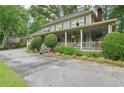 A view of the home's exterior, featuring a large porch, mature landscaping and a circular driveway at 177 Coopers Pond Dr, Lawrenceville, GA 30044