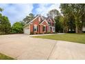 A lovely brick home with an attached garage and a large, well-maintained front lawn at 620 Reeves Hill Pt, Lawrenceville, GA 30043