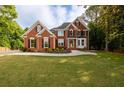 Charming two-story red brick home boasting a green lawn and manicured landscaping at 620 Reeves Hill Pt, Lawrenceville, GA 30043