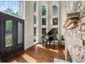 Elegant foyer with soaring windows, stone accents, piano, and hardwood floors at 7025 Kettering Ln, Suwanee, GA 30024