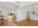Bright foyer with hardwood floors, decorative lighting, and an elegant staircase at 5059 Belair Bluff Se Ct, Smyrna, GA 30126