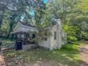 Quaint home showcasing a covered front porch, set amongst lush greenery for privacy and shade at 6385 Highway 92, Fairburn, GA 30213
